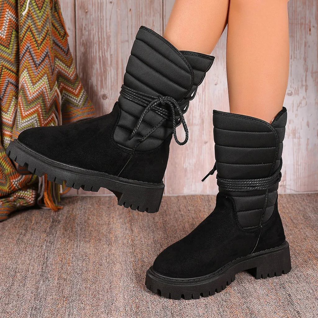 Black women's chunky heel snow boots with lace-up design and suede upper on a rubber sole