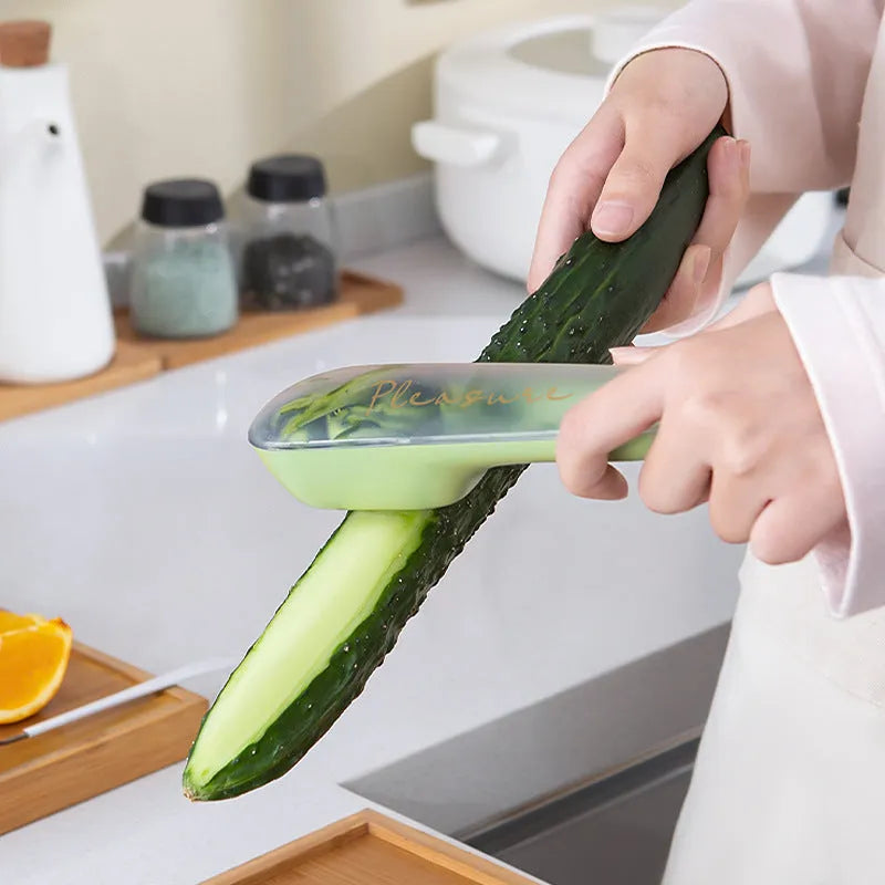 Dark green peeling knife with a storage tube over the blade and a hole in the end of the handle.