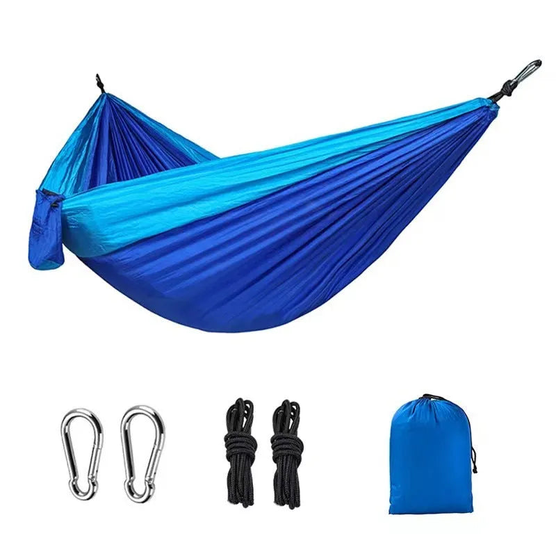 Blue nylon parachute cloth outdoor camping hammock hung between trees