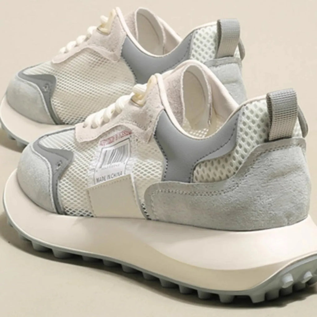 Women's low-top retro sneaker in grey or pink with round toe and rubber sole.