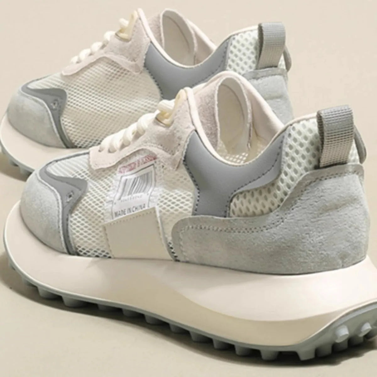 Women's low-top retro sneaker in grey or pink with round toe and rubber sole.