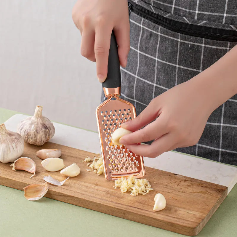 7-piece stainless steel kitchen tool set with copper plating in assorted colours on a countertop.