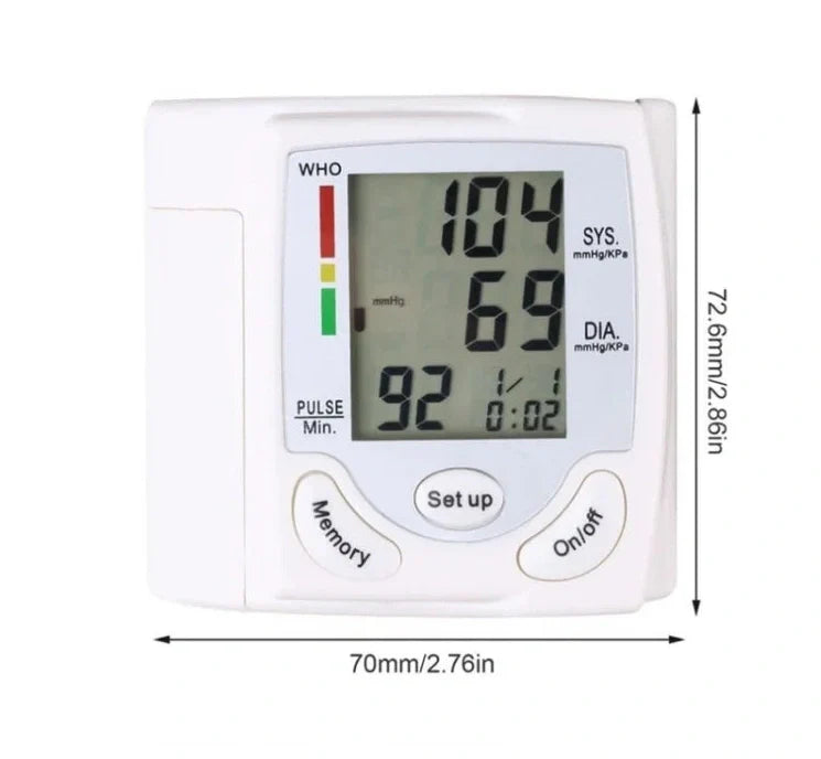 White wrist blood pressure monitor with digital display showing blood pressure readings and adjustable cuff