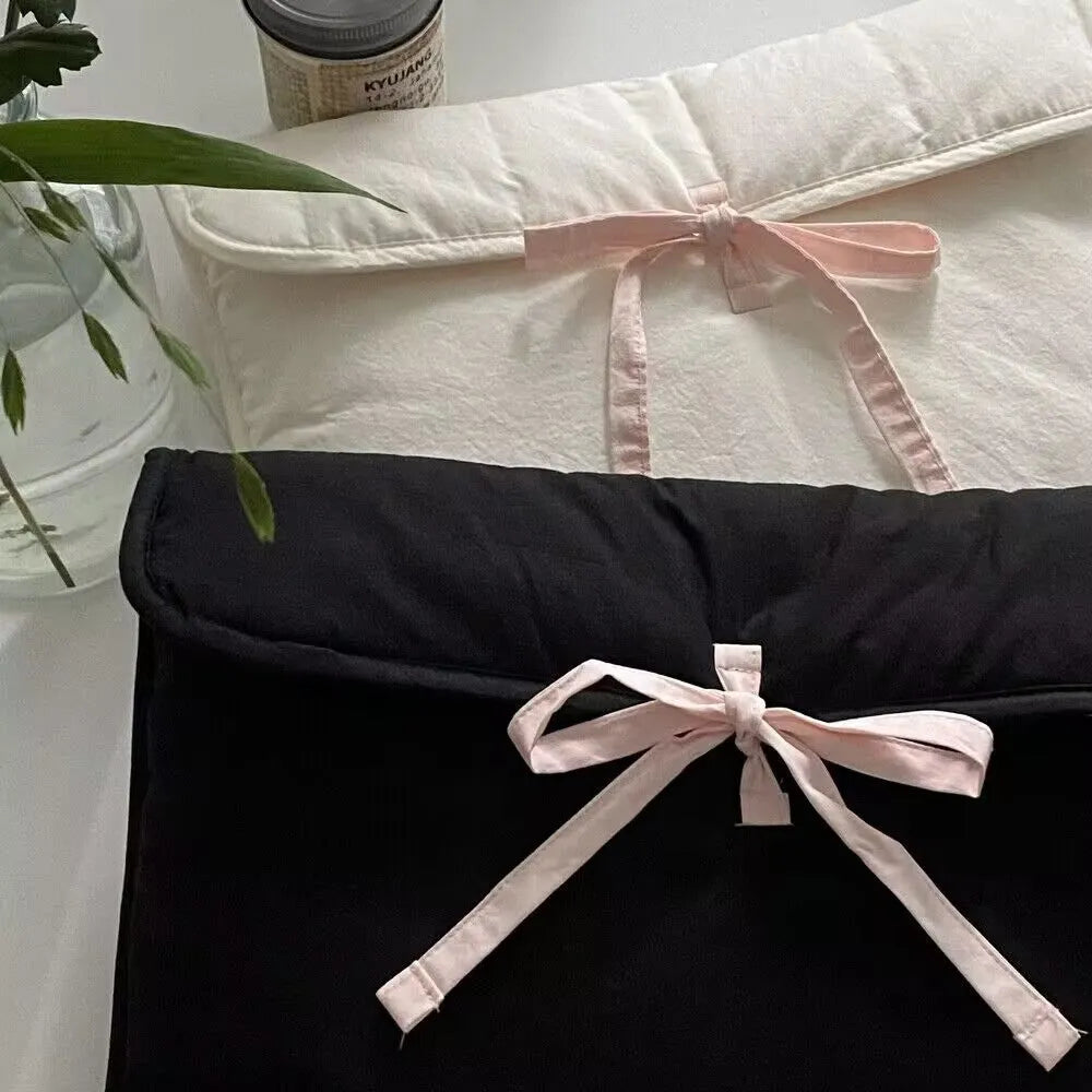 Women's black and white quilted laptop bag with ballet-style bow and striped nylon pattern