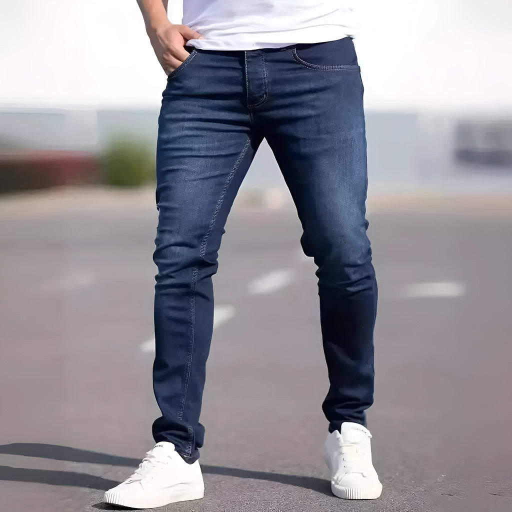 Men's dark blue slim-fit elastic cotton jeans with a skinny leg opening.