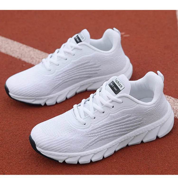 Women's low-top flat sneakers with cross-strap design in black and white colours