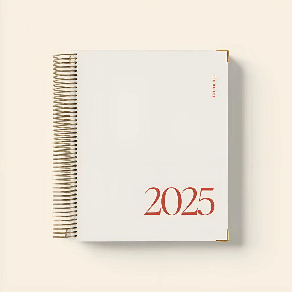 Cherry red daily schedule coil notebook open to show monthly planner pages and wire-o spiral binding
