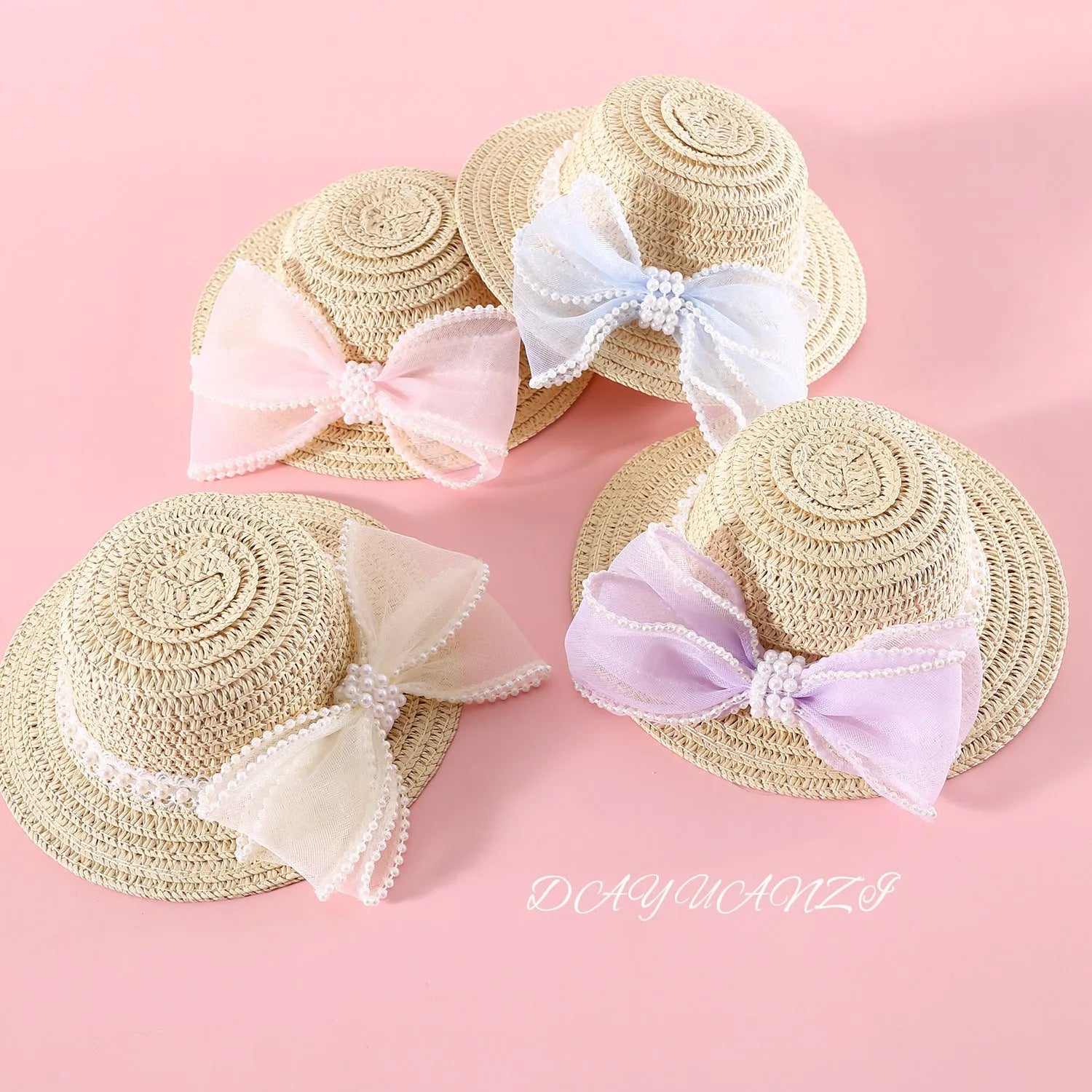 Pink pearl bow straw hat for a cat on a mannequin head, showing Lafite leaf weave and butterfly detail.