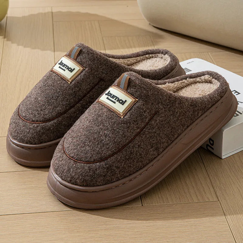 Men's brown suede slippers with a thickened design and textured EVA sole, shown on a wooden floor.