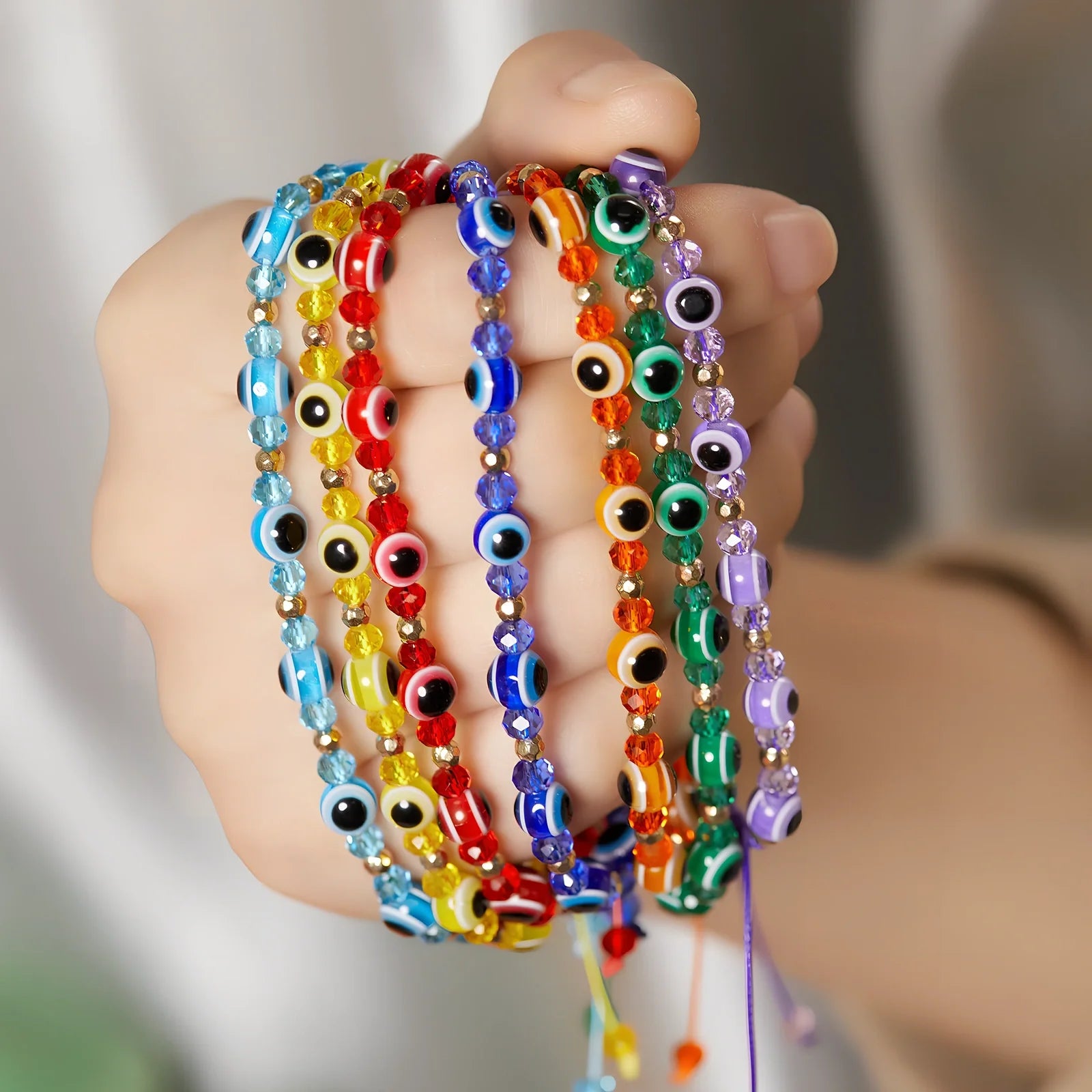 Adjustable crystal bead bracelet with blue eye design on braided rope, fits 15-19cm wrists