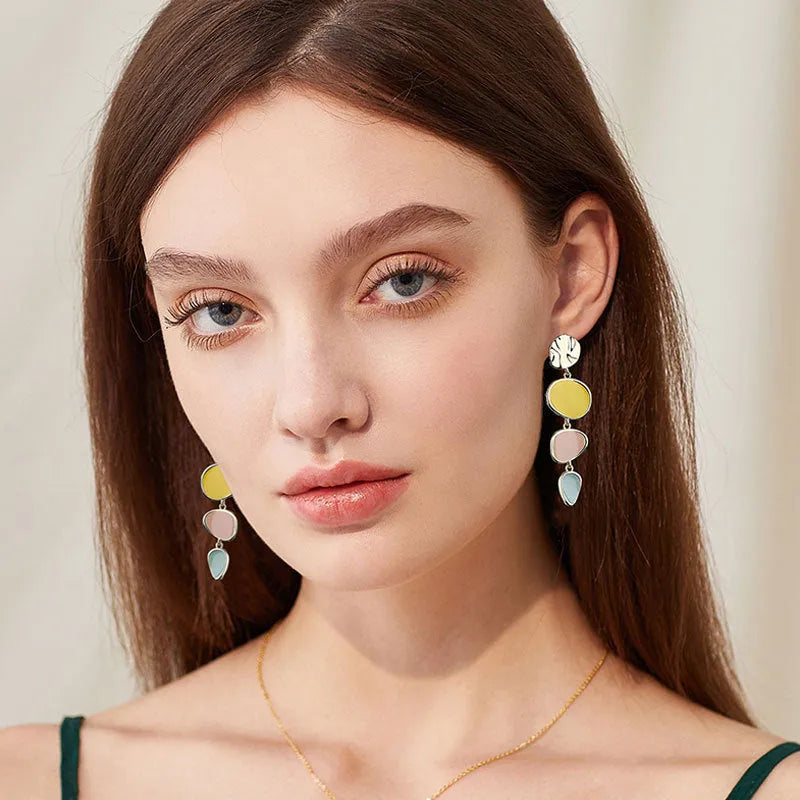 A pair of simple disc-shaped alloy earrings with a Morandi colour oil-drip finish on a sterling silver post.