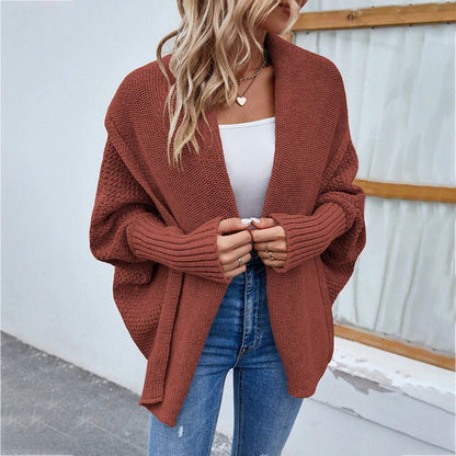 A cozy, oversized knit cardigan with a unique bat-wing sleeve design and large lapel, available in a variety of stylish colors.