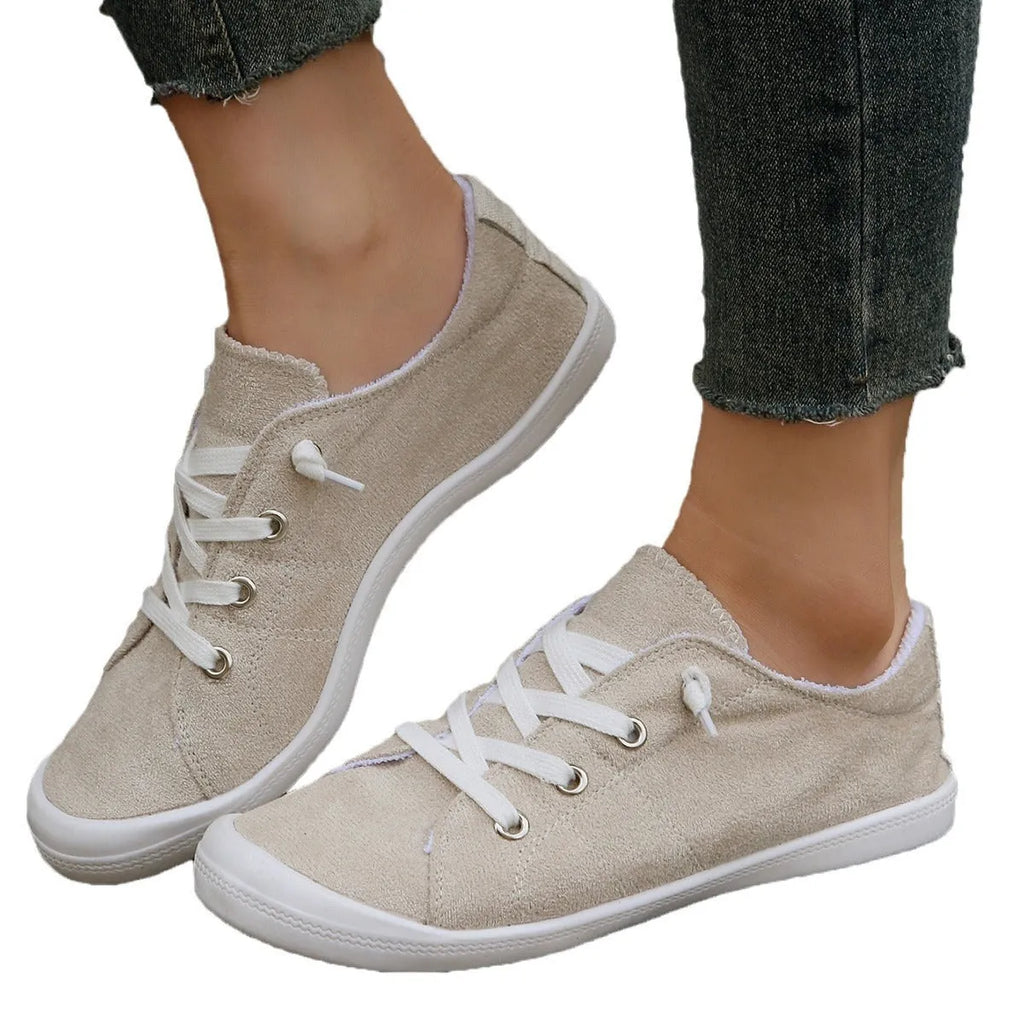 Women's creamy white low-top fabric sneakers with a casual rubber sole on a neutral background