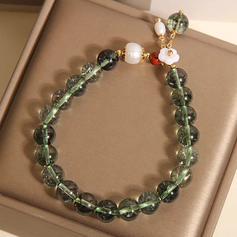 Green phantom quartz crystal bracelet for women with a small white shell flower accent.