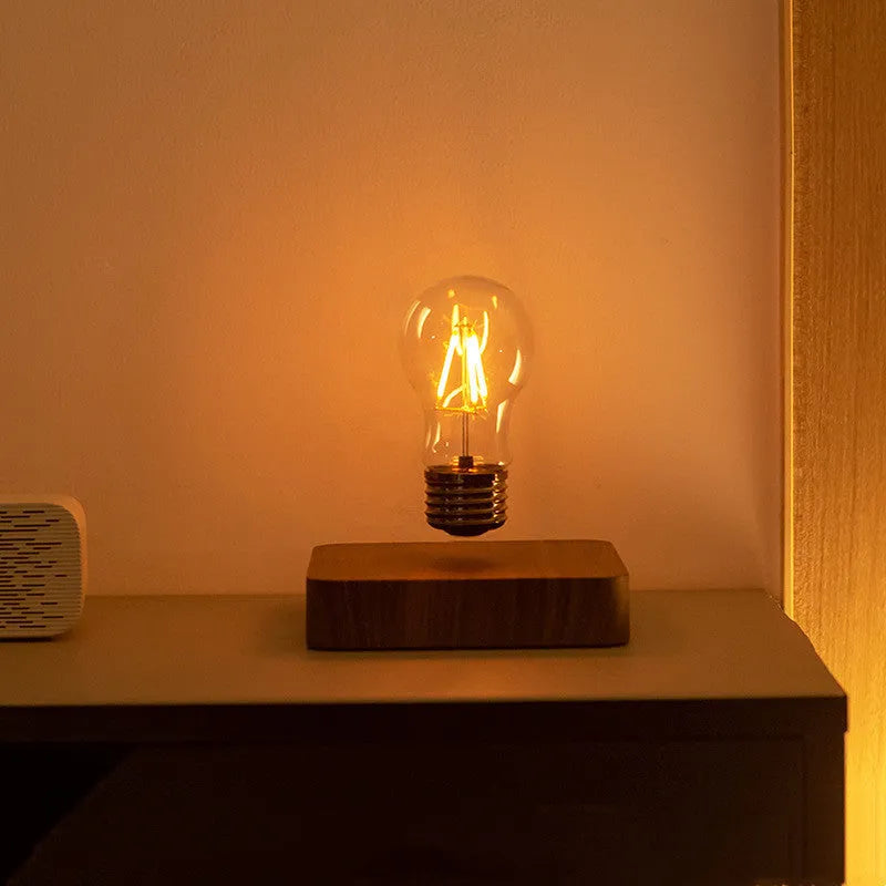 Self-rotating wireless powered maglev bulb with warm yellow light on a compact ABS base