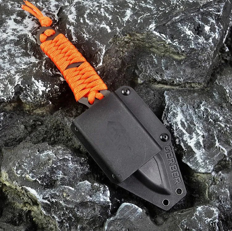 Straight survival knife with rope handle and black ABS sheath on a paper box.