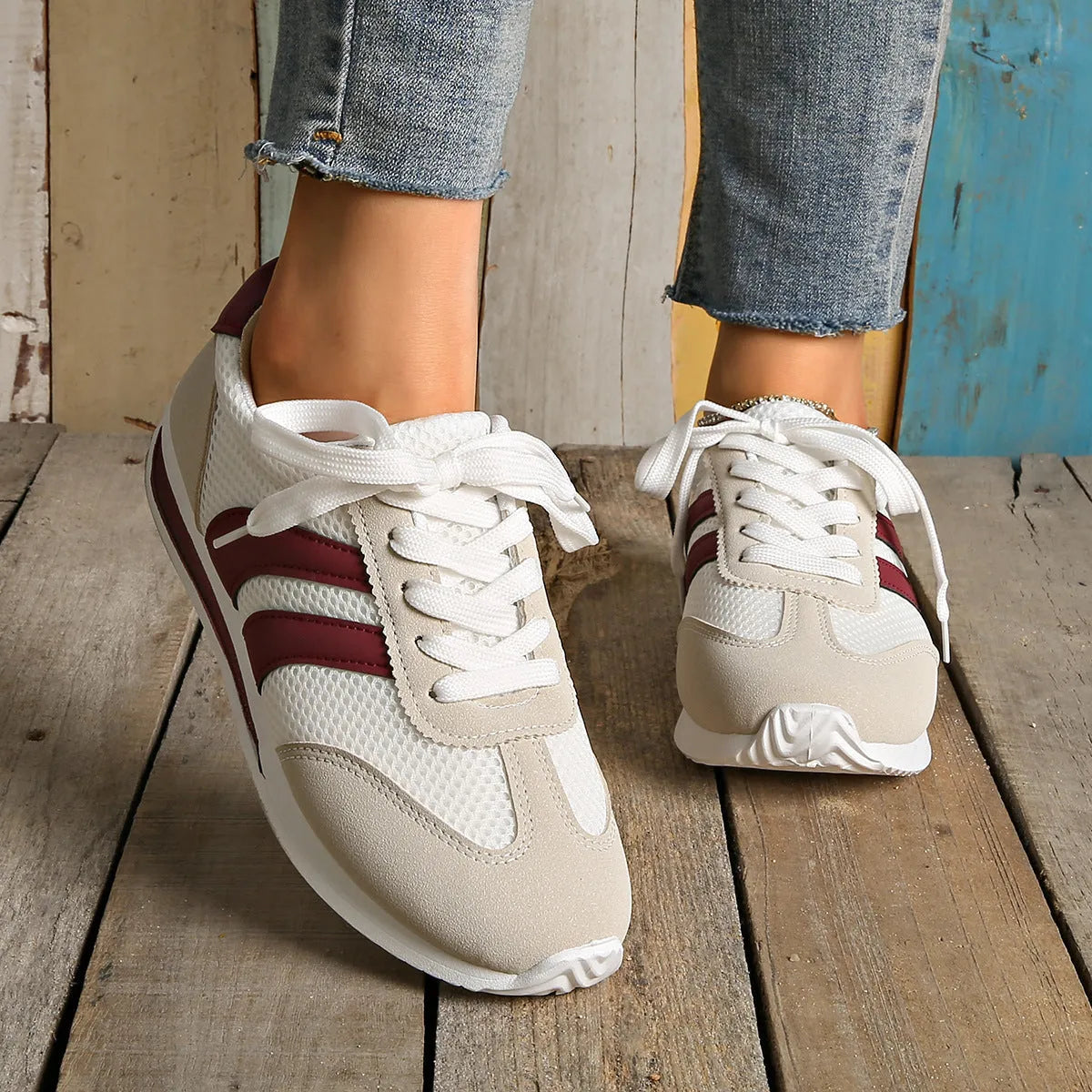 Wine red Cortez-style casual sneakers with a cross-strap detail and mesh lining.