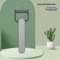 Green and grey dog detangling comb with stainless steel teeth on a polypropylene handle.
