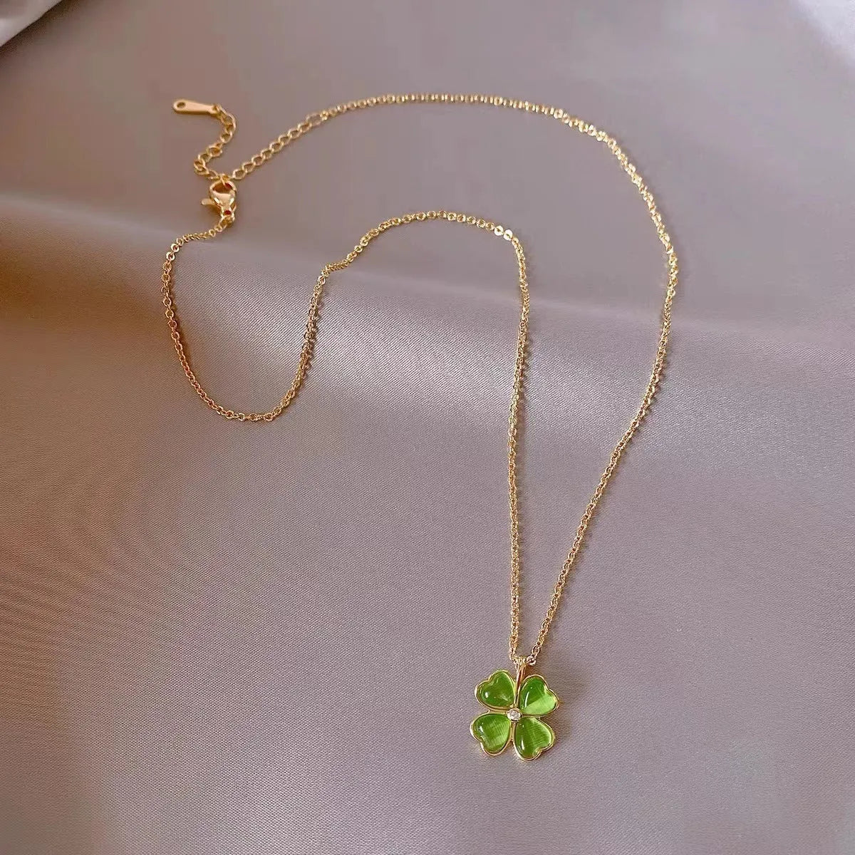 Titanium steel golden clavicle chain with geometric four-leaf flower design on unisex display