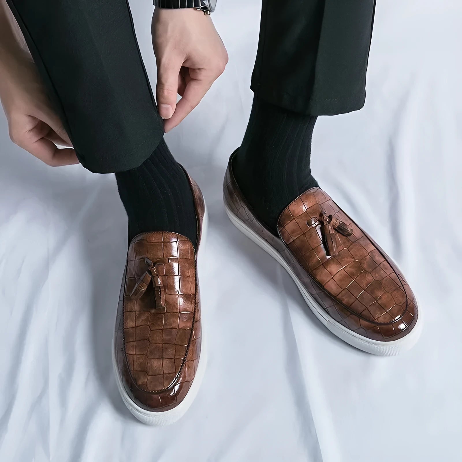 Men's black artificial PU sneakers with tassel detail and a round toe, displayed on a white background.