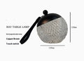 Small cylindrical portable night lamp with touch dimmer in chrome, gold, black, coppery brown, or white finish.
