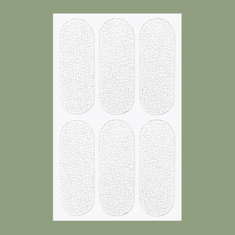 Close-up of transparent and frosted disposable TPU ear patches on backing paper, 0.1cm thick.