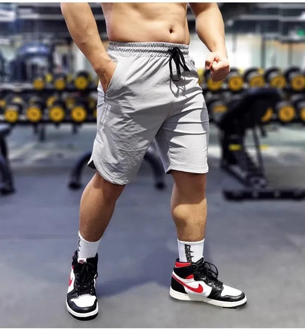 Men's black quick-dry running shorts made of nylon and spandex on a grey background