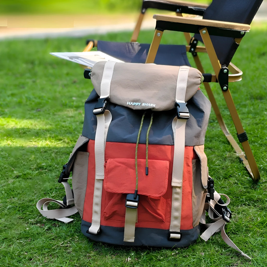 Orange and green contrast colour large outdoor backpack with multiple compartments on a neutral background.