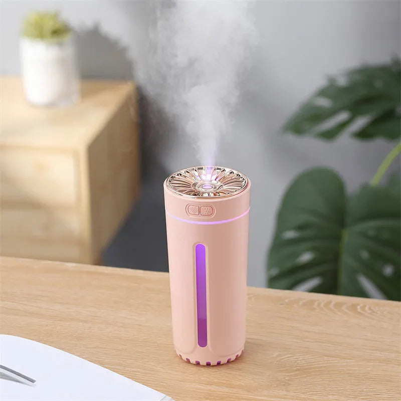 Compact black wireless USB humidifier with colourful LED lights on a car cup holder.