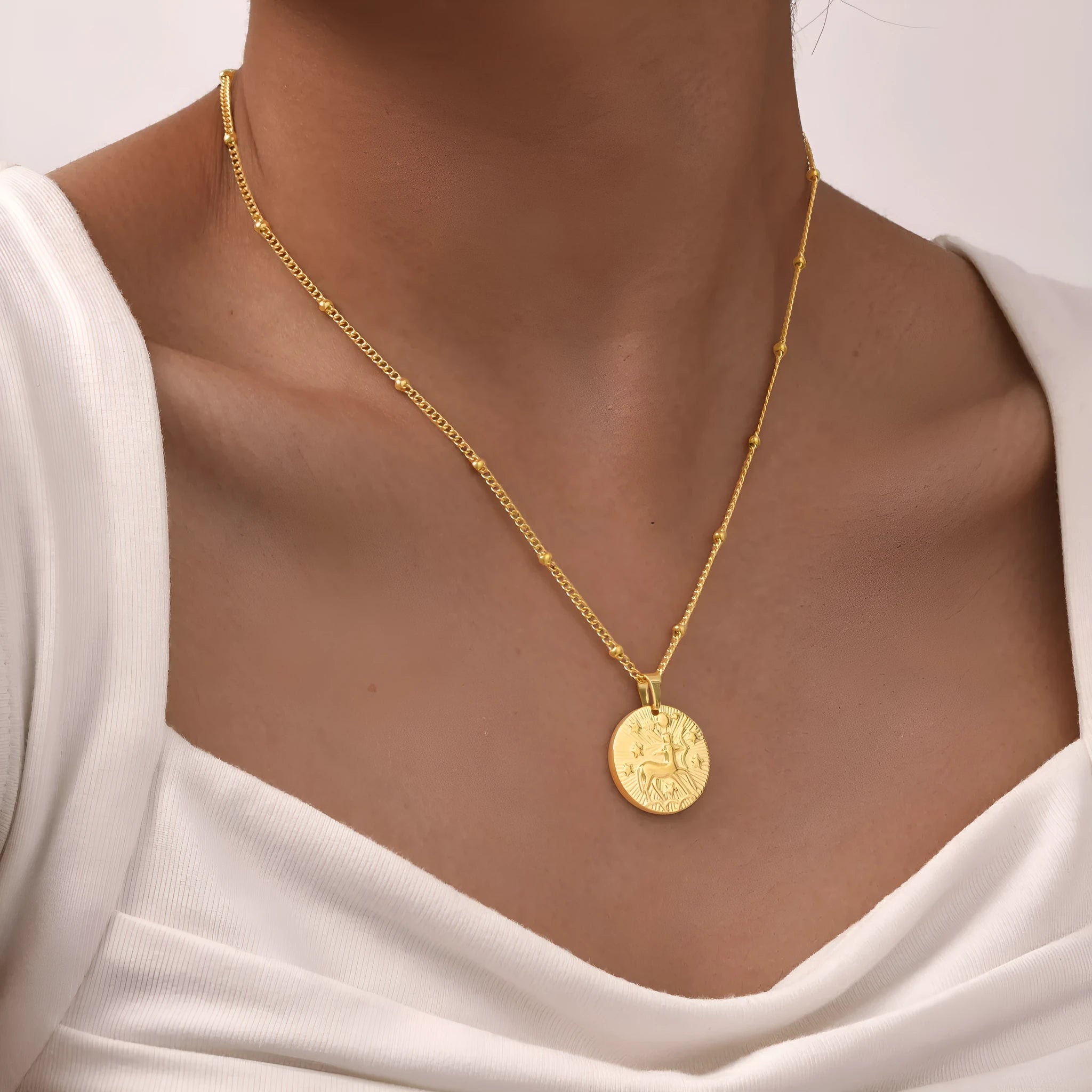 Silver stainless steel zodiac necklace with geometric round pendant showing embossed constellation design