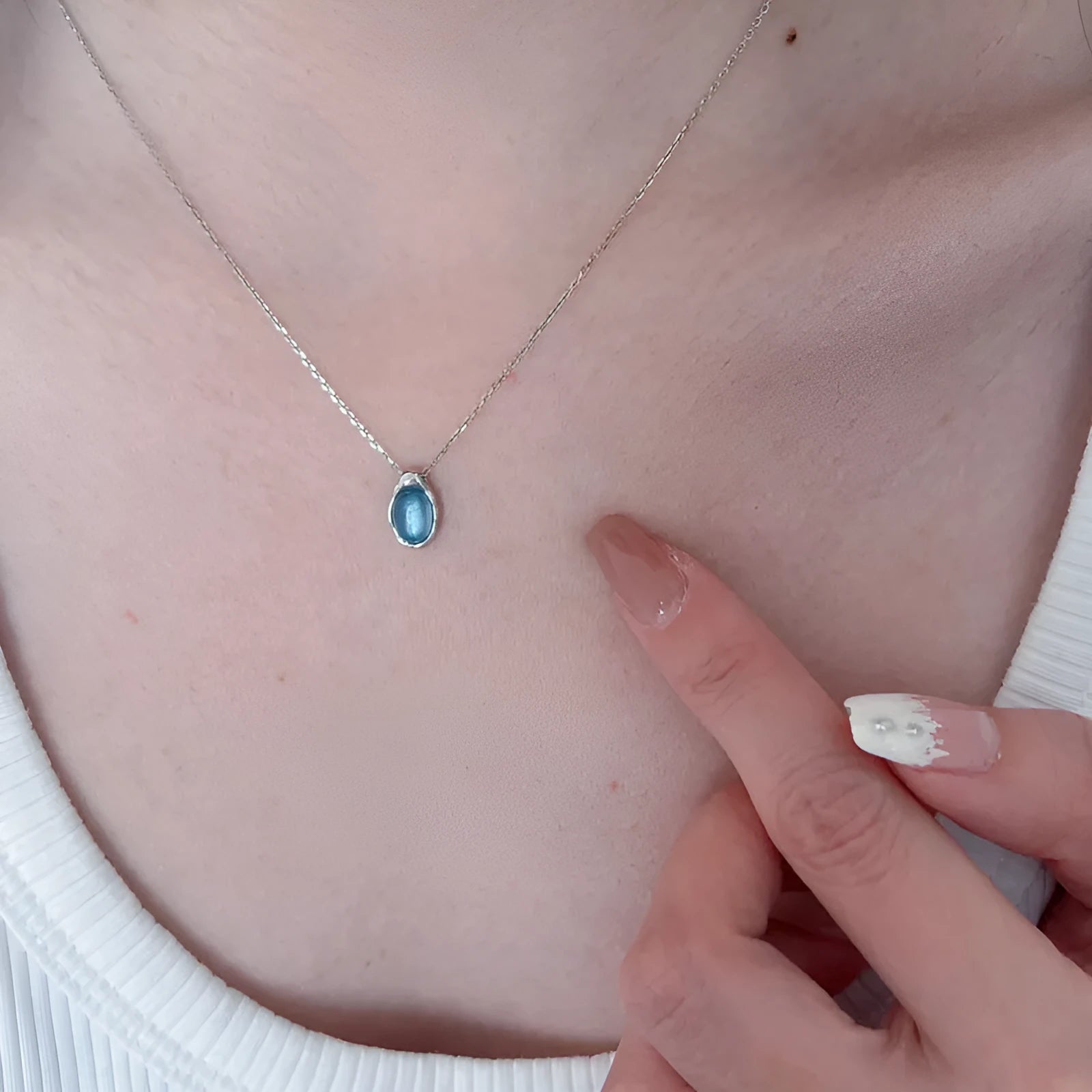 Geometric navy blue water droplet pendant necklace on a platinum-coloured adjustable chain.