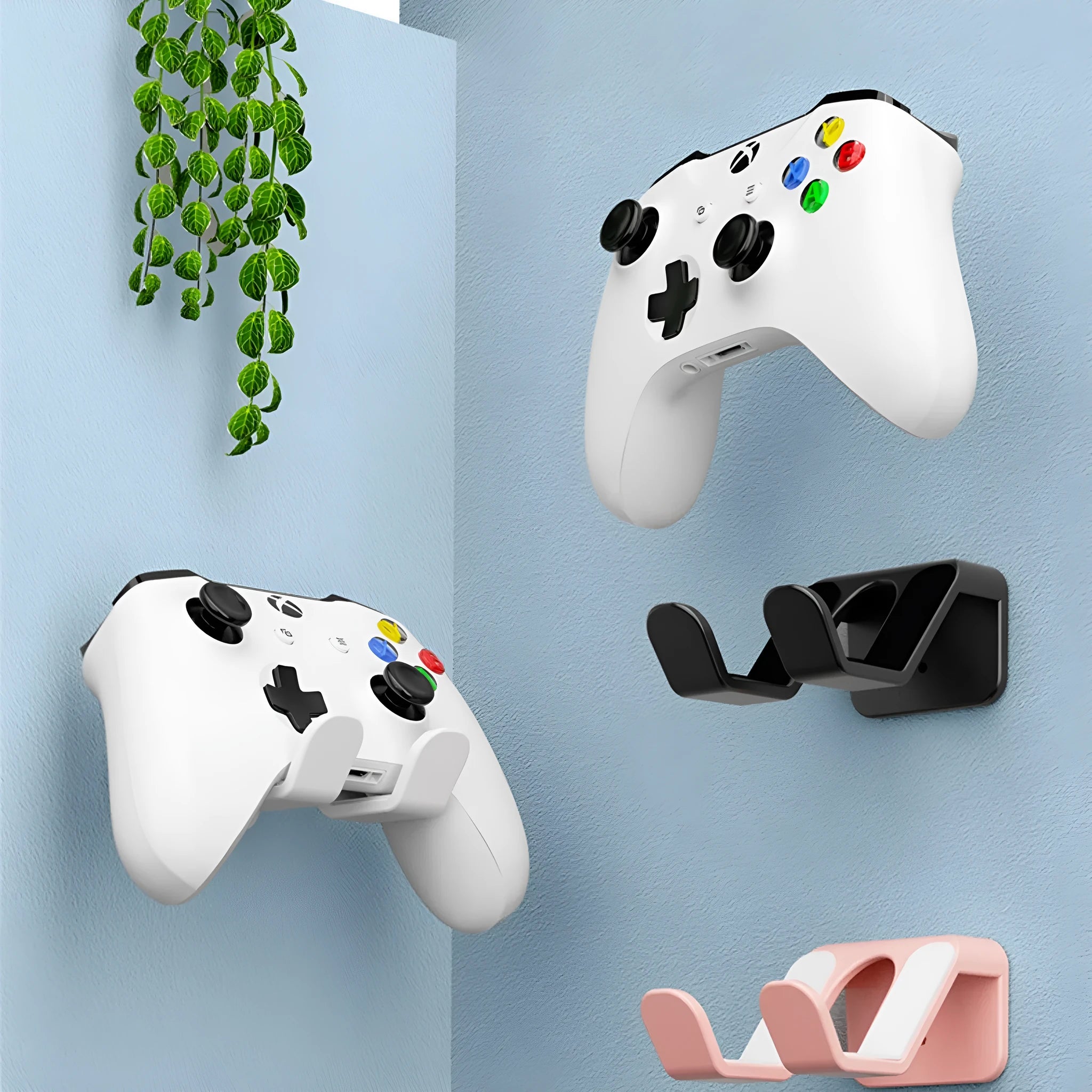Black non-perforated wall rack holding two game controllers, mounted with adhesive.