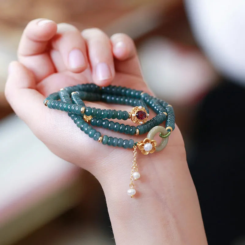 Blue water jade abacus bead bracelet with tourmaline and pearl accents on a wrist