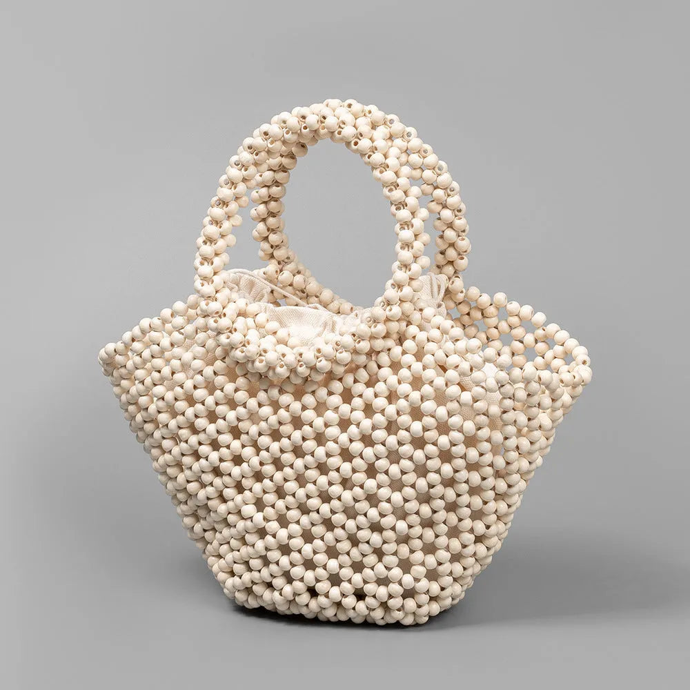 Maple wood woven dumpling-shaped handbag with wooden bead decoration, shown in milky white.