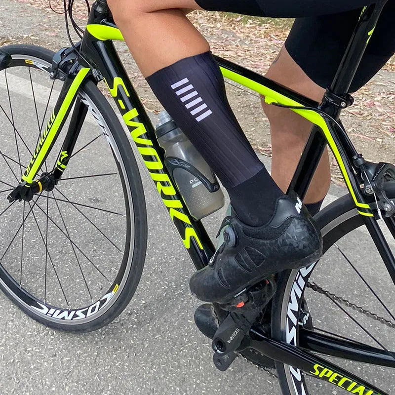 Cycling and running socks in chemical fibre blend fabric shown in orange, black, purple, white, grey, and dark blue colours.