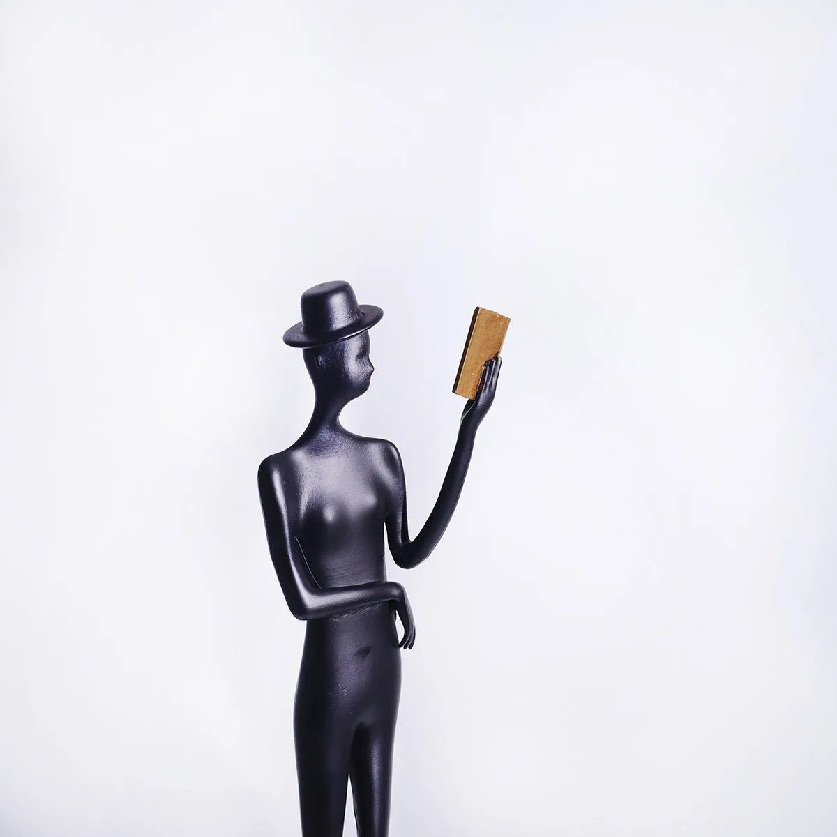 Black cast aluminium desktop sculpture of a woman reading, modern simplicity style, 51cm tall.