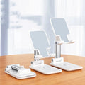 Black desktop wireless charging phone holder standing upright with a mobile phone on it.