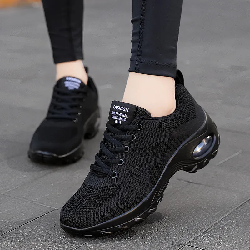 Red and black women's low top lace-up mesh sneakers with a round toe and mid heel.