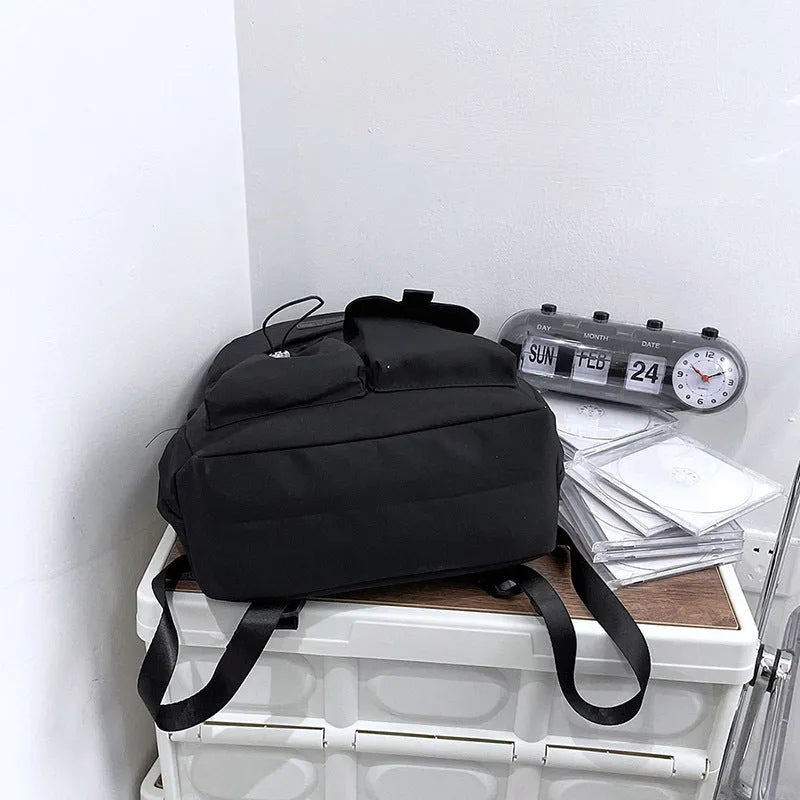Nylon backpack school bag for junior high students, waterproof, lightweight, available in black, blue, pink, and white colours