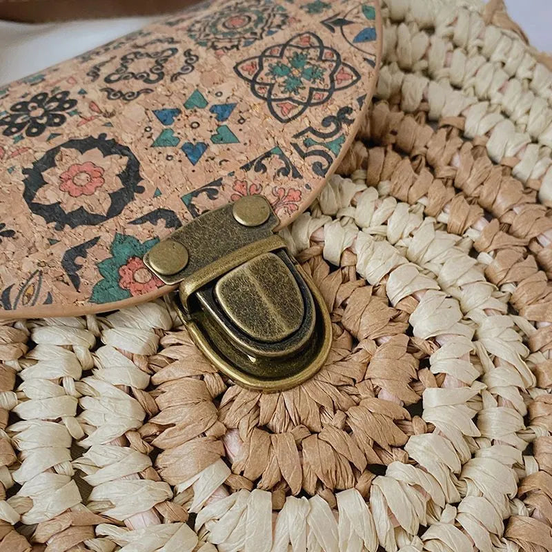 Round straw woven crossbody bag in beige, 25cm diameter, with adjustable shoulder strap, displayed on a neutral background