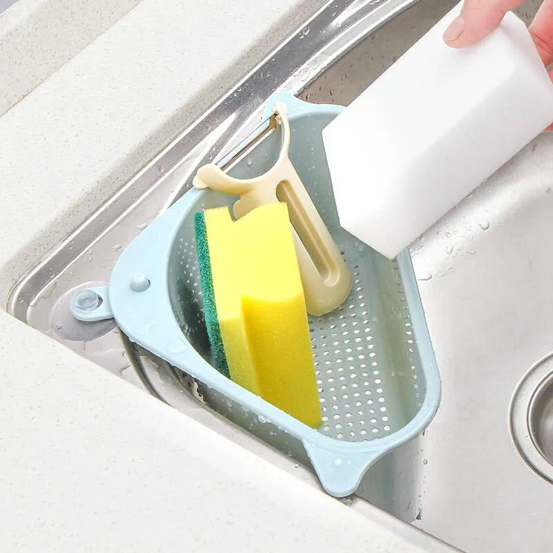 Beige plastic triangle sink storage rack for draining sponges, shown mounted on a kitchen faucet.