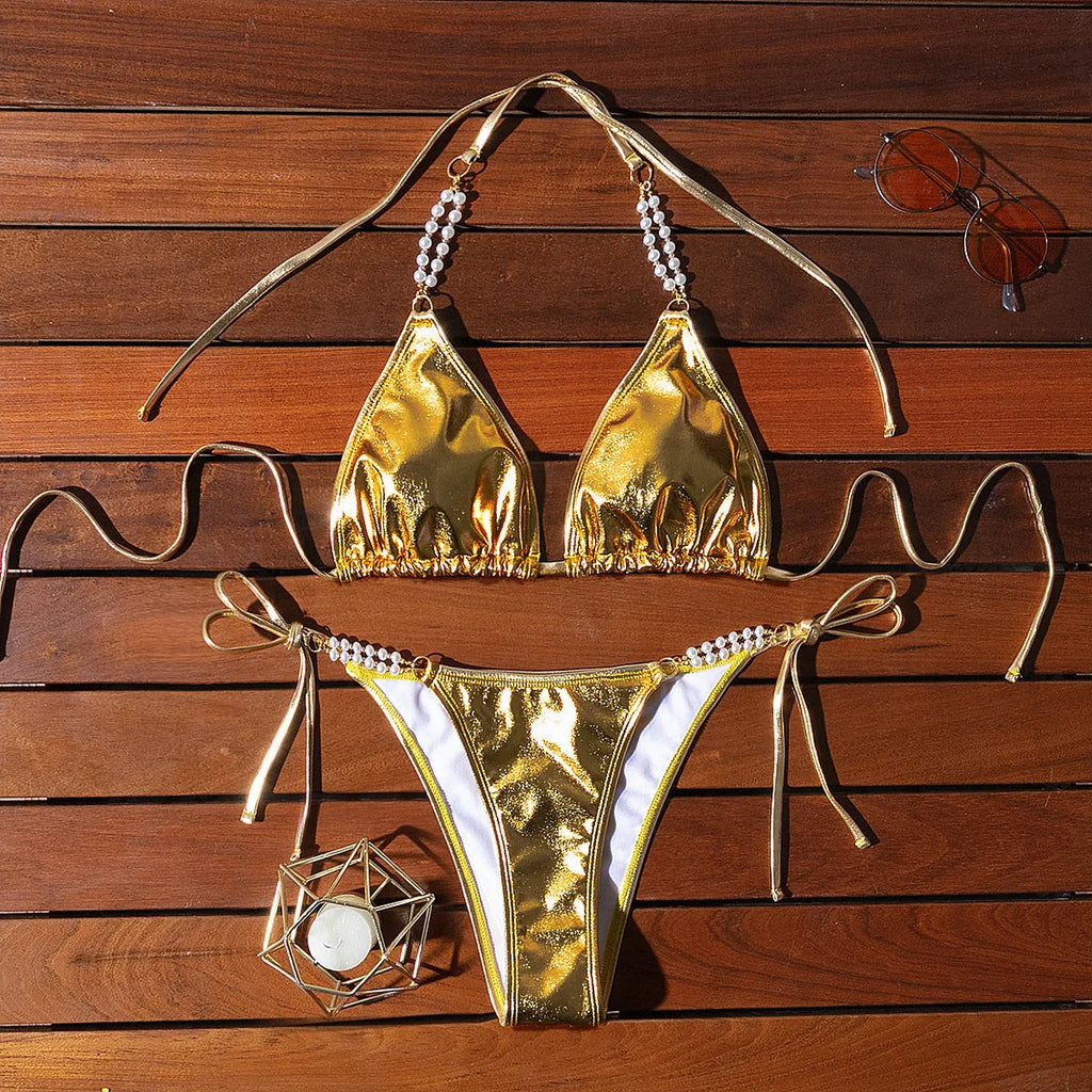 Gold women's bikini swimsuit with halter neck, lace-up back, and pearl chain decoration
