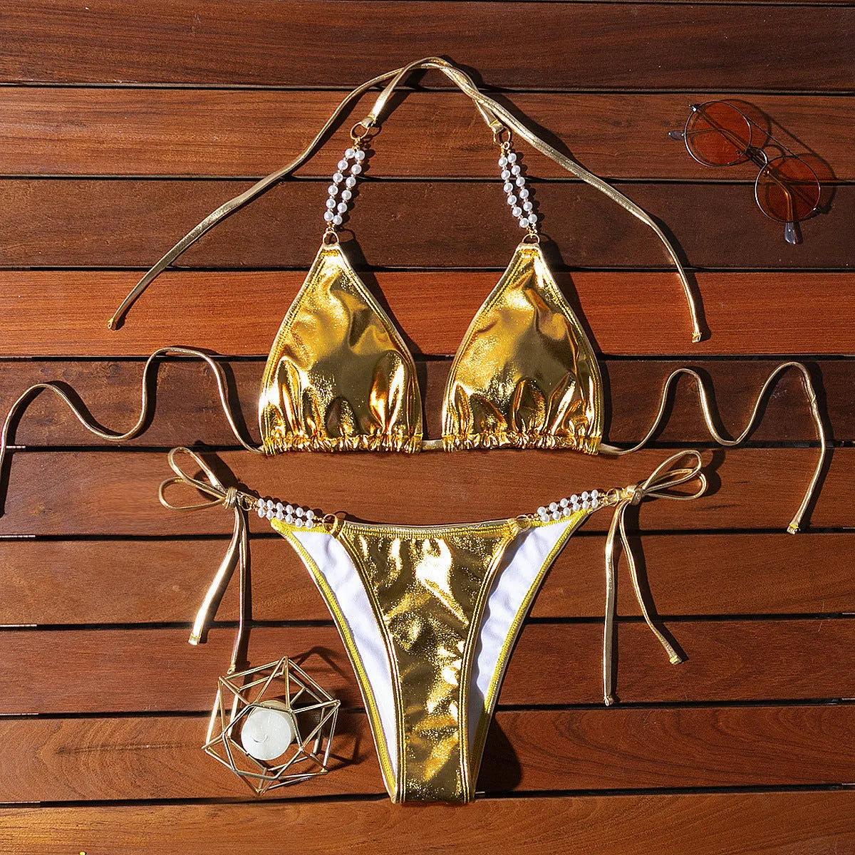 Gold women's bikini swimsuit with halter neck, lace-up back, and pearl chain decoration