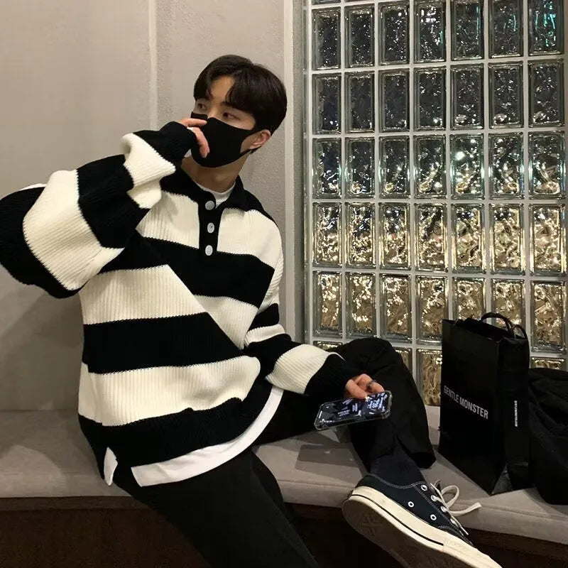 Man modelling a loose fit black and grey striped polyester sweater coat, long sleeve pullover style.