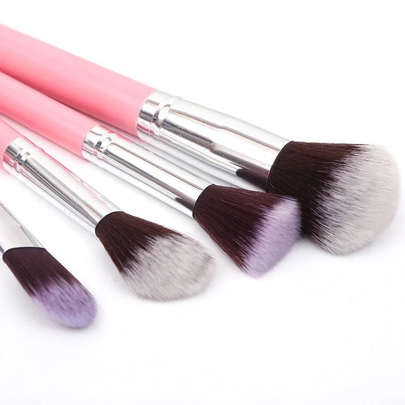 12 makeup brushes with pink handles and black bristles arranged in white storage bucket
