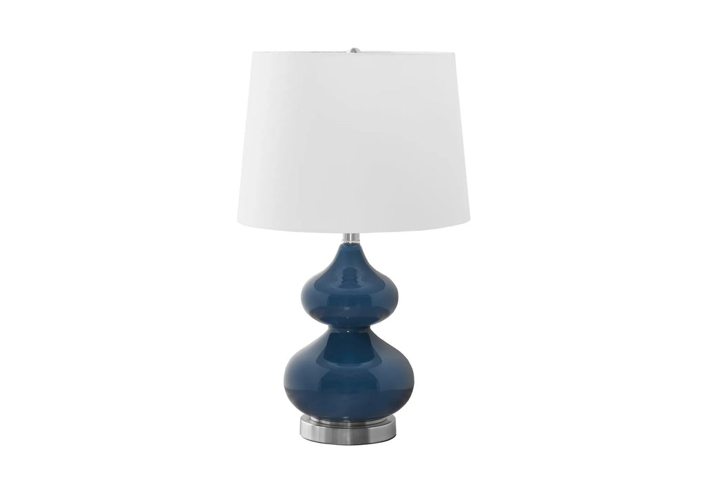 Blue crystal glass desk lamp with a white fabric shade on a wooden desk.