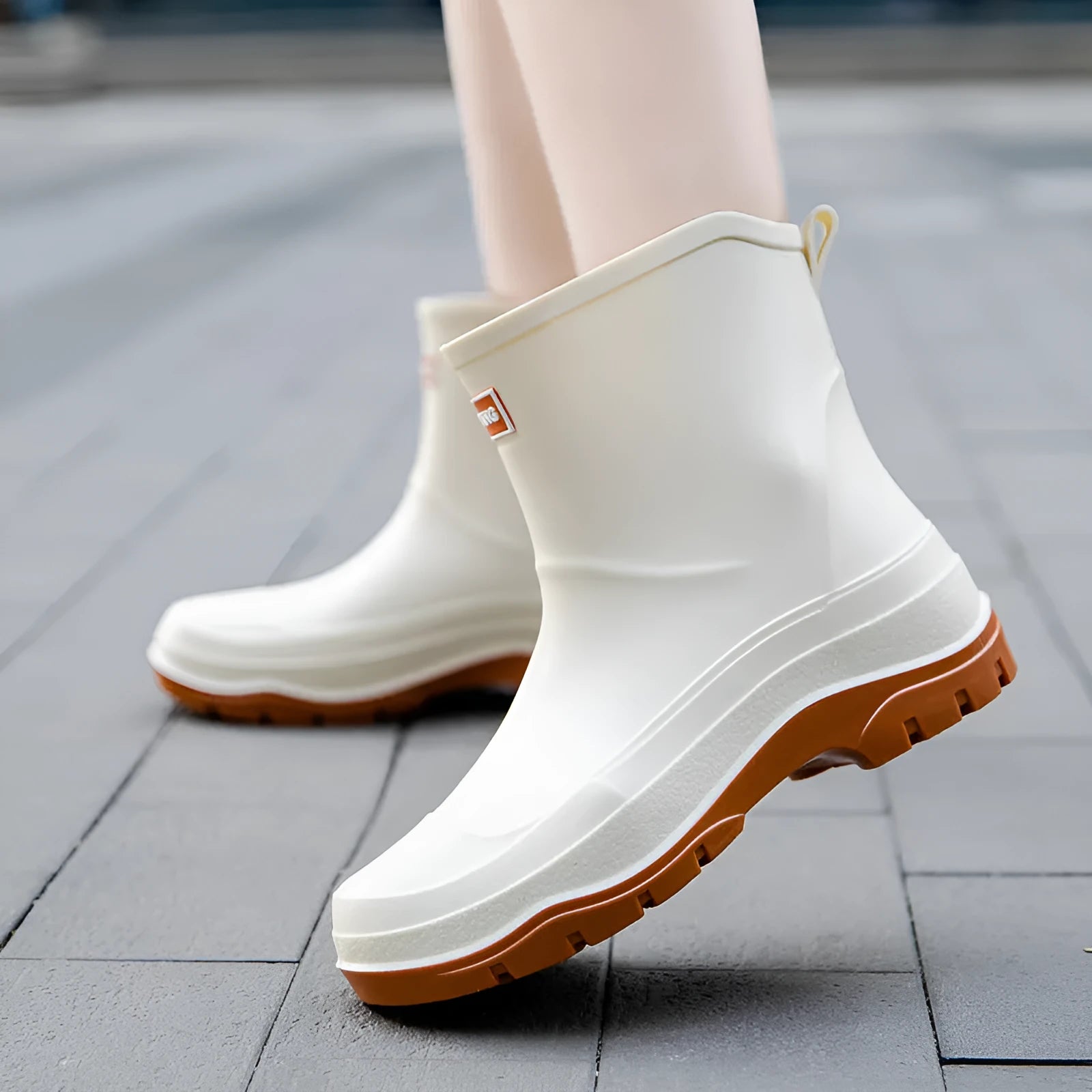 Women's short waterproof rubber shoe with non-slip sole in white colour on a flat heel.