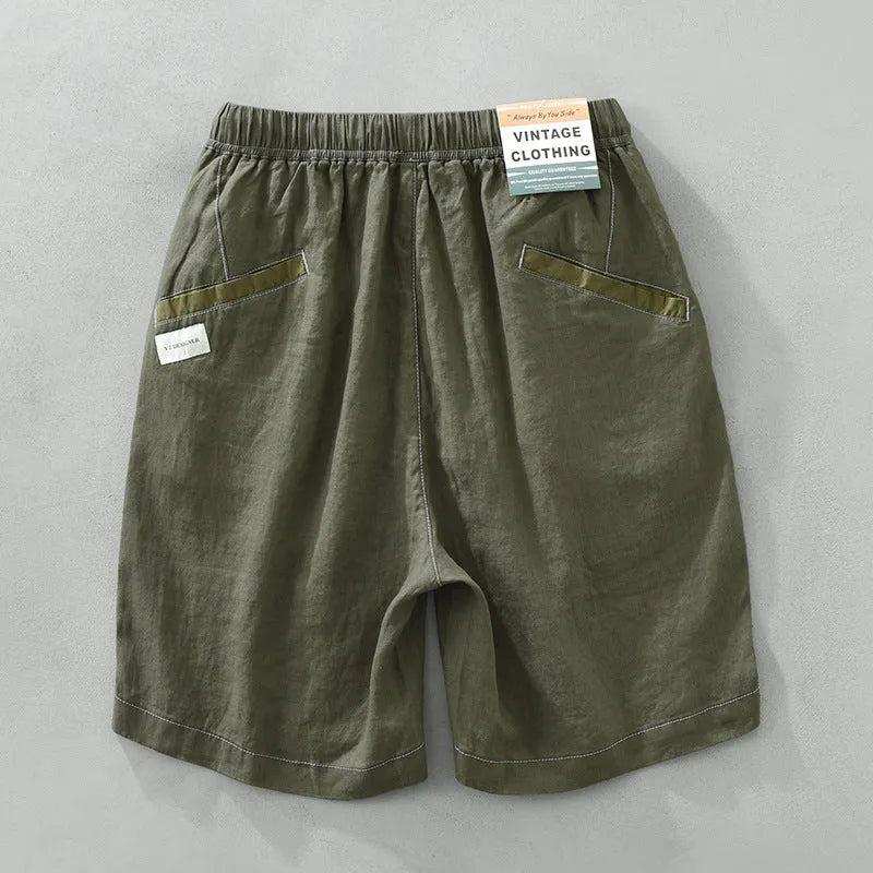 Men's loose straight fit linen shorts in green with drawstring waist, shown laid flat