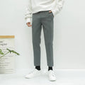 Men's slim straight-leg cotton trousers with a drawstring waist in black, shown front and side.
