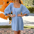Light blue children's backless dress with square collar and puff sleeves on a mannequin.